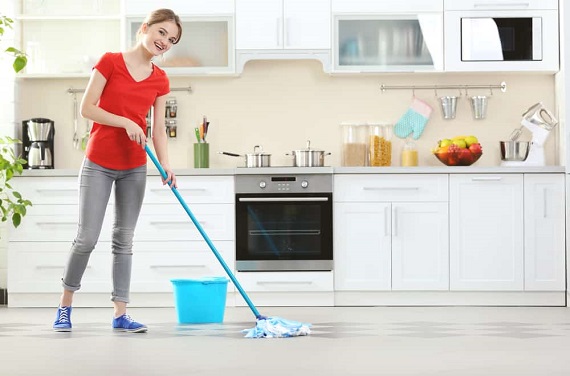 A woman sweeping he vinyl floor in the kitchen