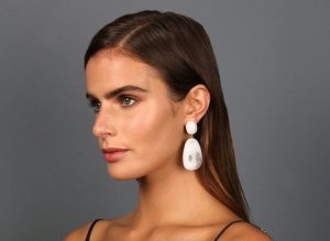 woman wearing white resin earrings