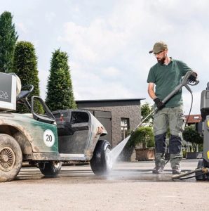 A person using a electric pressure washer to wash away the dirt of a car