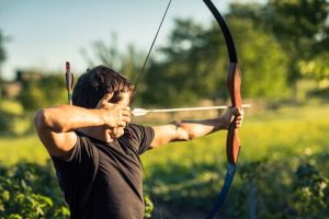 man in the nature holding archery recurve bows
